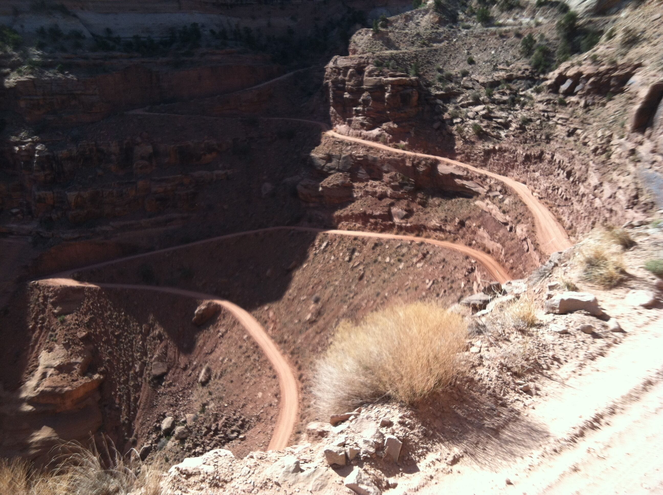 A rugged canyon with a winding dirt road.