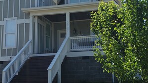 Een huis met twee verdiepingen, een veranda, een trap en een brievenbus met het nummer 3737.