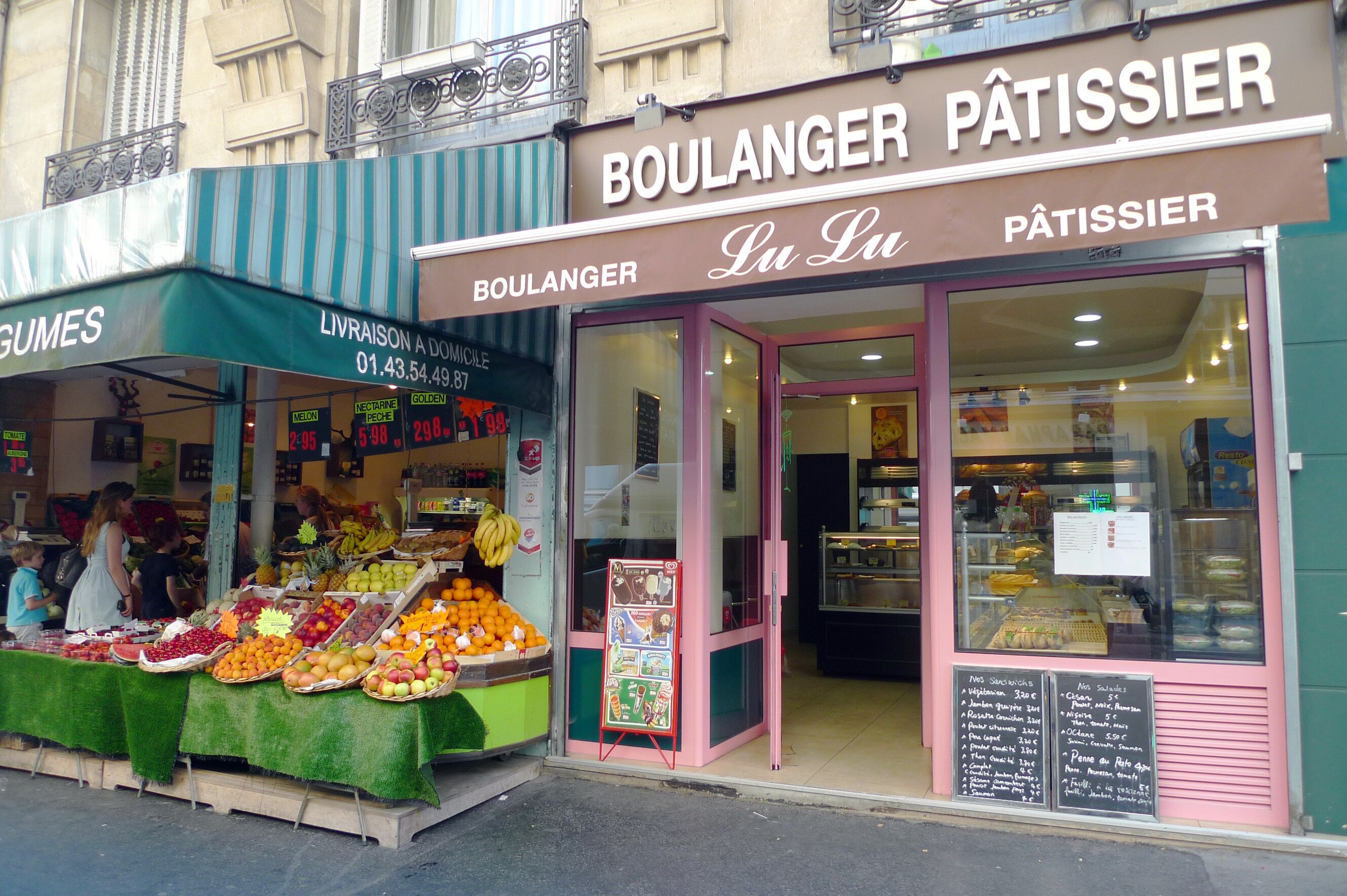 Een winkel met een fruitkraam ervoor en een bakkerij binnen.