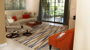 Un salon comprenant un canapé, un fauteuil, une table basse et un tapis à rayures.