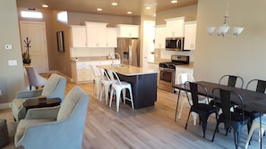 Enjoy meals in the spacious kitchen and dining area, featuring a central island, comfortable seating, and modern appliances.