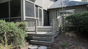 A house with a porch, a screened porch area, and a small garden with steps leading up to the entrance. - 604 Tennismaster, OWNER Mgmt, Beach Locker, Handicap & Family Friendly (Hilton Head Island)