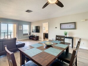 A dining area with a wooden table, chairs, and a ceiling fan. - Come Relax And Enjoy What The Beach Has To Offer (Indian Rocks Beach)