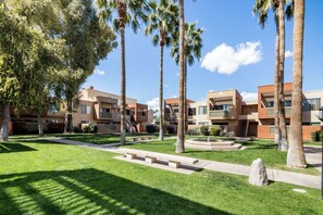 Residents can enjoy outdoor living spaces with balconies and large windows, a well-maintained lawn, and palm trees.