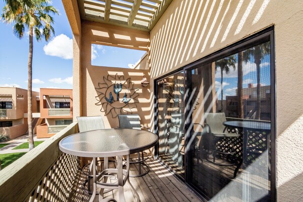 Enjoy dining or socializing in this patio area with a view of the surrounding buildings and palm trees.