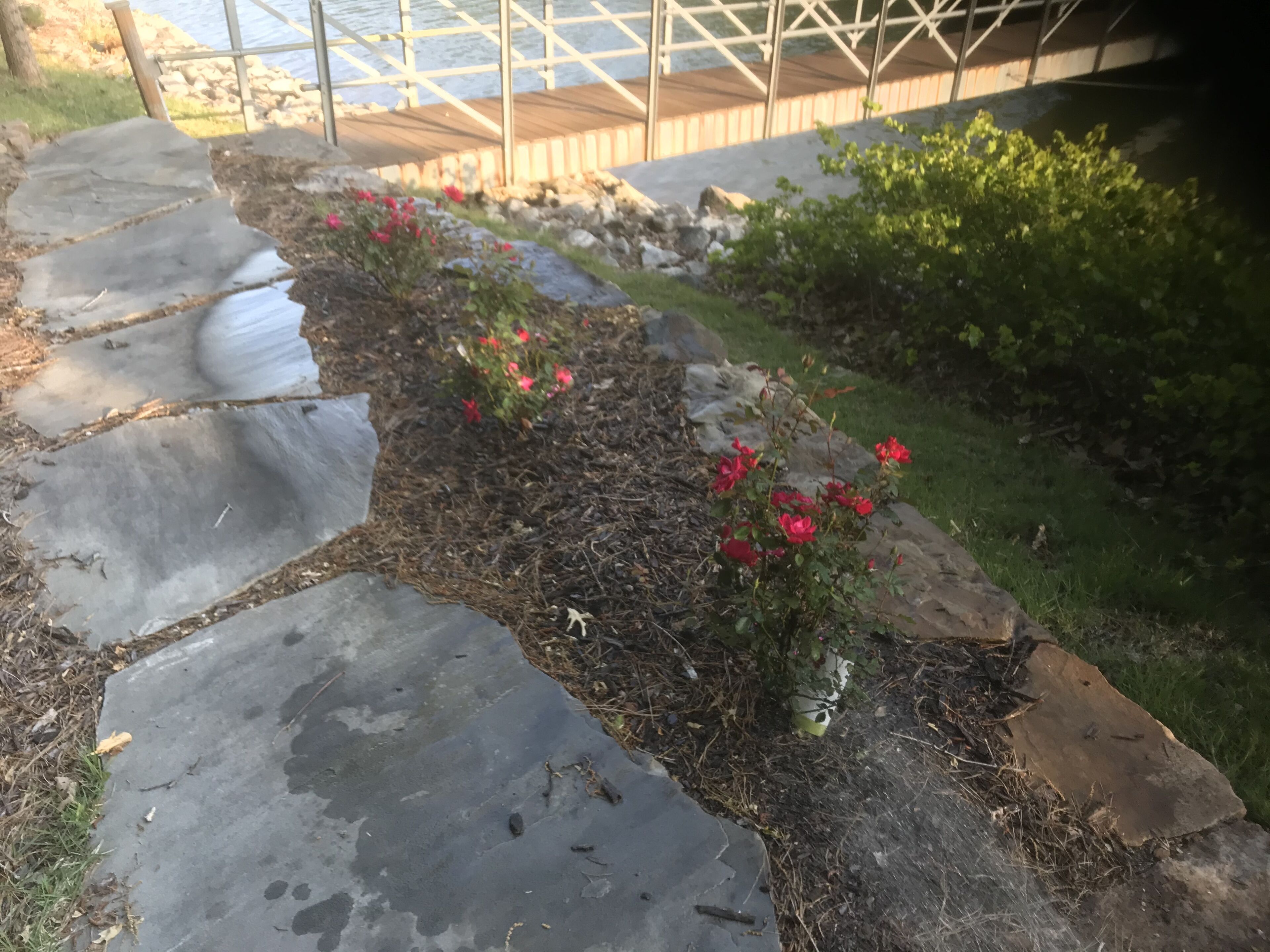 A stone pathway leading to a wooden deck over water.