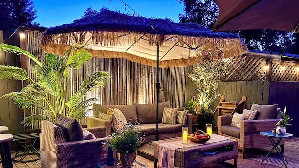 An outdoor seating area with wicker furniture, a thatched roof, and string lights. - Updated Furnished Cottage With New BBQ, spa, and Pool - small pet considered (Chico)