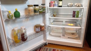 An open refrigerator with various food items and condiments. - Updated Furnished Cottage With New BBQ, spa, and Pool - small pet considered (Chico)