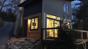 Een modern herenhuis met twee verdiepingen, een stenen fundering, grote ramen en een houten gevel.