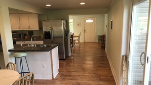 A kitchen with a stainless steel refrigerator, a sink, and wooden flooring. - Only 2 blocks to beach, one block to kids corner, over half an acre! (South Haven)