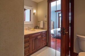 Une salle de bain avec des meubles en bois, un lavabo, un miroir et des toilettes.
