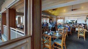 Un restaurant doté de mobilier en bois et d’un balcon donnant sur la salle à manger.