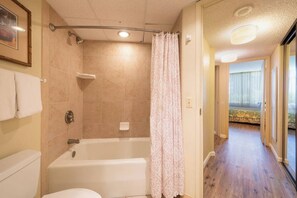 Een bad/douchecombinatie, een haardroger, handdoeken, zeep