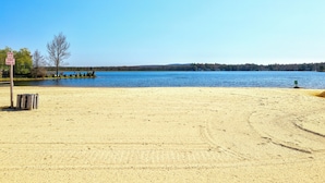 A beach with a clear view of a lake, a sign indicating no smoking, and a few trees. - WolfRun Lake View Chalet, 200 feet from Lake, Hottub (Albrightsville)
