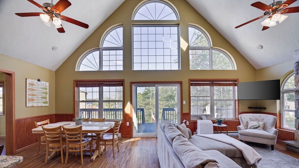 A spacious living area with a high ceiling, large windows, and a ceiling fan. - WolfRun Lake View Chalet, 200 feet from Lake, Hottub (Albrightsville)