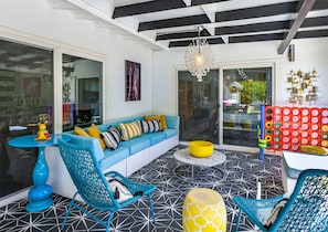 A modern living room with a blue sofa, a round yellow table, and a blue chair.
