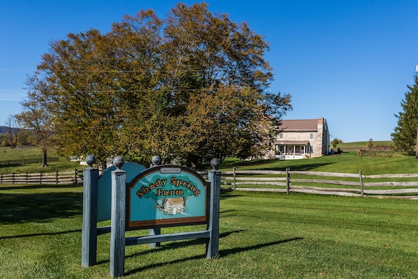 Shady Spring Farm's welcome signs and stone farmhouse.