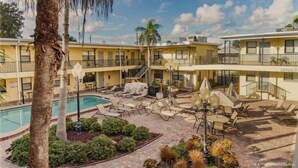 A hotel with a pool, outdoor seating, and a two-story structure. - Adorable One Bedroom One Bathroom With Easy Access To The Beach!  (Redington Beach)