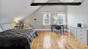 Une chambre à coucher avec un lit, un bureau, une chaise et une commode.