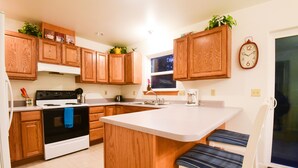 Una cocina con armarios de madera, una estufa y un lavabo.