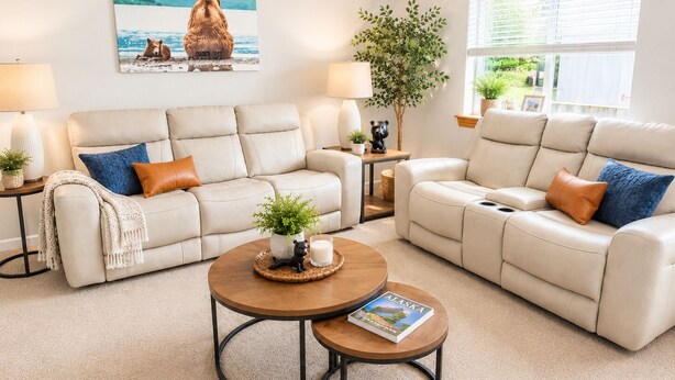 Una sala de estar con un sofá color beige, una mesita de centro y una estantería.