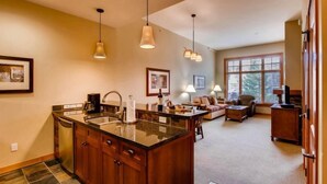 A spacious kitchen with a large island, wooden cabinets, and pendant lighting. - Capitol Peak Lodge 3123 (Snowmass Village)
