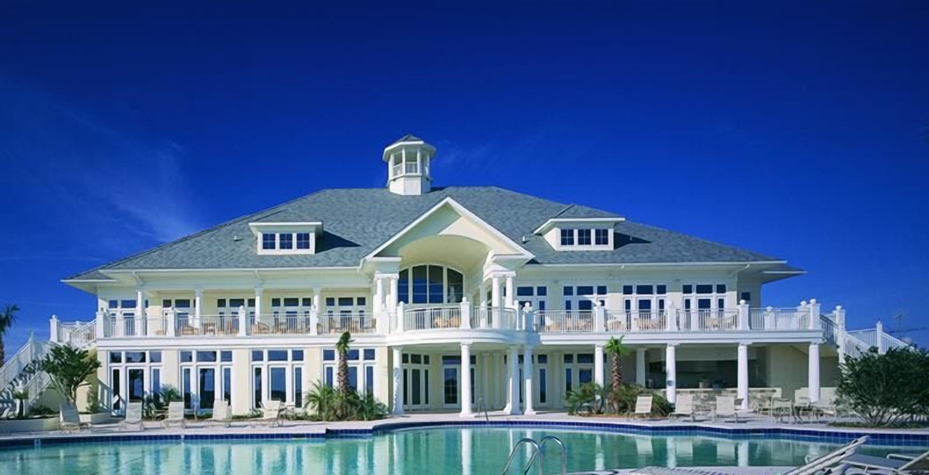 A large resort with a swimming pool, multiple balconies, and a grand entrance.