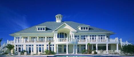 A large resort with a swimming pool, multiple balconies, and a grand entrance.