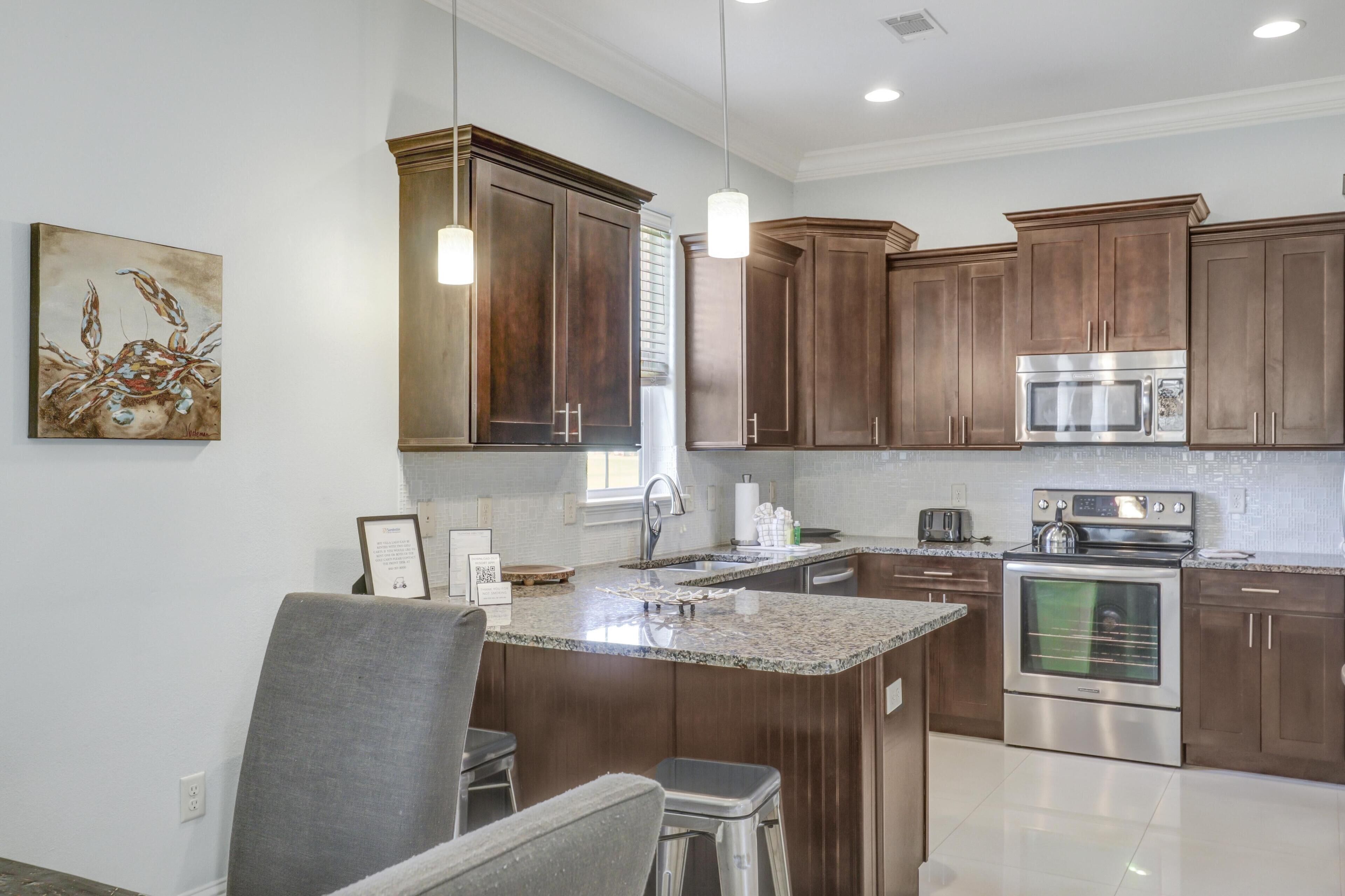 A modern kitchen with dark wooden cabinets, stainless steel appliances, and a granite countertop.