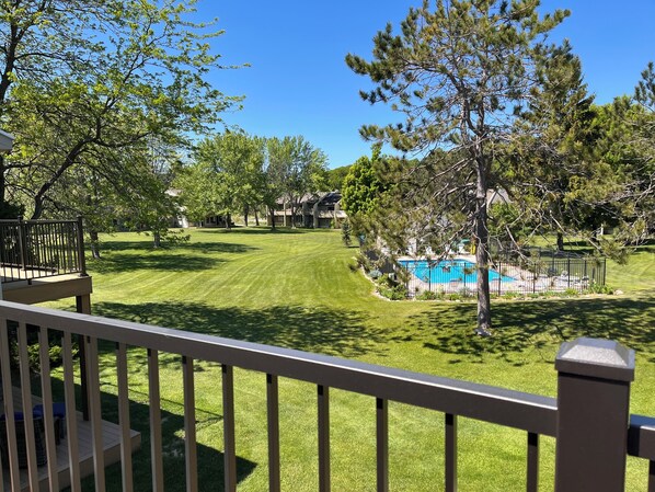 Un giardino privato con piscina, un pontile in legno e un prato curato.