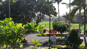 A parking area with a stop sign, surrounded by lush greenery and palm trees. - Beautiful 2/2 Townhouse in Princeville, Free WiFi, Cable TV, BBQ, beach gear (Princeville)