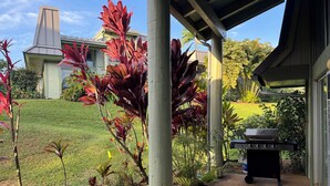 A covered patio with a grill, potted plants, and a view of a house with a chimney. - Beautiful 2/2 Townhouse in Princeville, Free WiFi, Cable TV, BBQ, beach gear (Princeville)