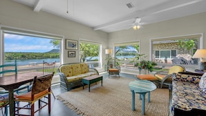 A spacious living room with large windows, a dining area, and a view of a lake. - Million-dollar View & Affordable Too! Kayaks free for use (Kingsland)