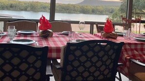 A restaurant with checkered tablecloths, dining tables, chairs, and a view of a lake and mountains. - Million-dollar View & Affordable Too! Kayaks free for use (Kingsland)