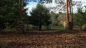 A sign for Lilikoï Resort with a natural backdrop of trees and a grassy area. - Vacation Rental in Westfield/Oxford, Wis., with acres of nature … (Oxford)
