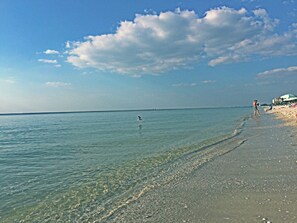 Enjoy a serene beach experience with umbrellas providing shade and access to the clear blue waters.