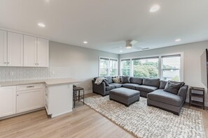 Relax in the spacious living area with a large sofa and matching ottoman, or enjoy a meal at the kitchen bar.