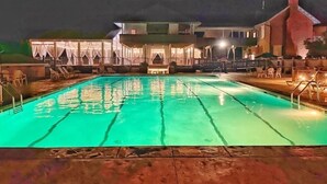 A swimming pool with a view of a building in the background. - Romantic SML Penthouse, Bernard’s Landing. Smith Mountain Lake 3 Pools (Moneta)