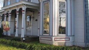 A two-story house with a bay window and a porch with columns. - Historic Home - Victorian Stage Coach Inn (Russellville)