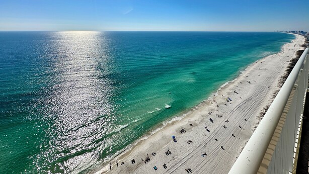 A beach with clear turquoise waters and a sandy shore.
