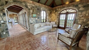 A spacious interior with a stone wall, a white sofa, and a wooden chair.