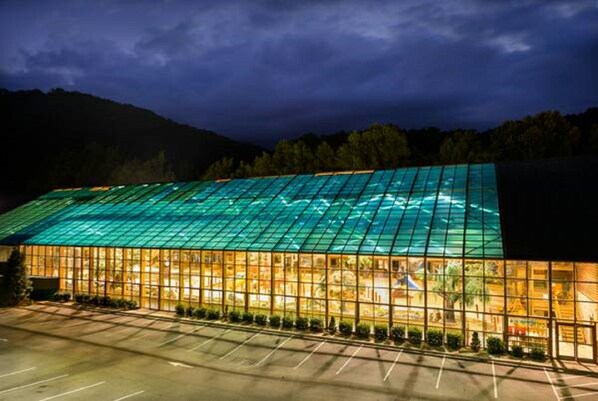 Un edificio moderno con una grande facciata in vetro e un parcheggio antistante.
