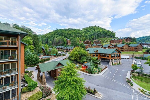 A lodge with multiple wooden cabins, a central building, and a parking area surrounded by greenery.
