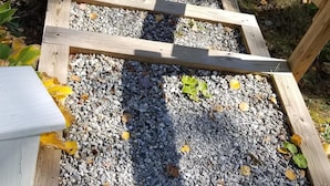 Un escalier en bois avec un chemin de gravier menant à un véhicule.