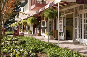Guests can walk along the covered path lined with plants to the hotel entrance, marked by a sign with suite availability.