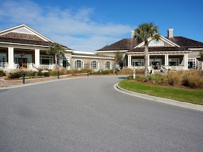 A two-story building with a curved driveway, large windows, and a covered entrance area with columns.