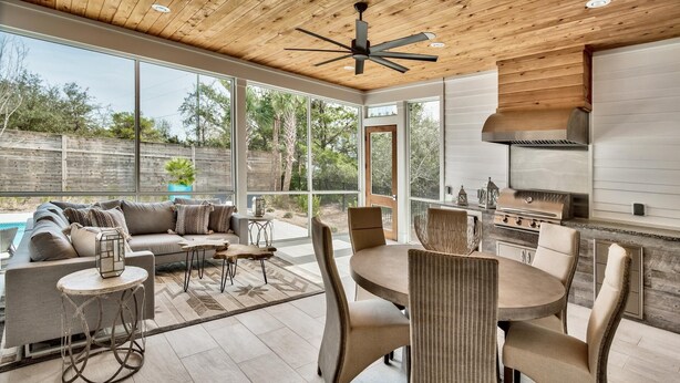 Un espacio exterior con piscina, comedor y parrilla.