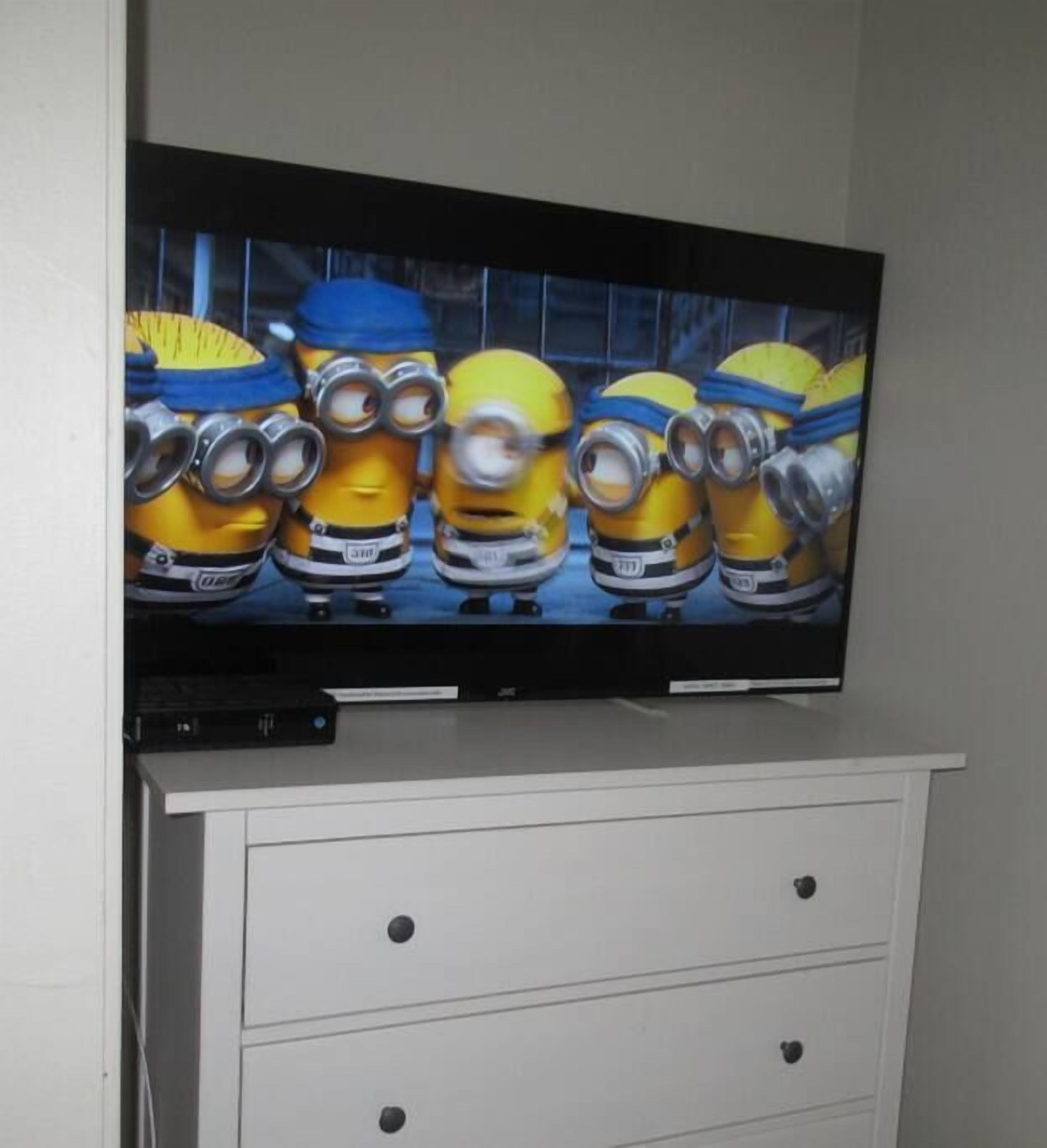 A television displaying an animated film featuring characters with goggles and blue helmets.