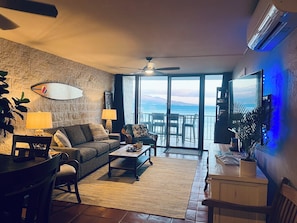 Relax in this ocean-view living area with a sofa, dining table, and large flat-screen TV.