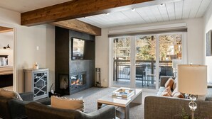 Una sala de estar acogedora con chimenea, asientos cómodos y vistas al exterior.